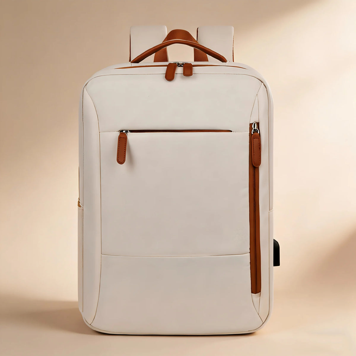 A cream-colored backpack with brown leather accents, including the top handle, zipper pulls, and vertical side strap, shown against a warm beige background.
